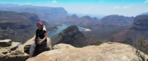 A traveller resting on rocks above a river canyon in South Africa